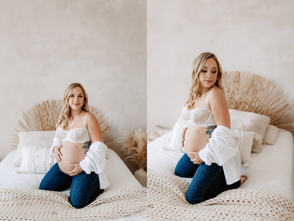 Pregnant woman kneeling on bed in white lace and jeans during light and earthy maternity session in Tampa Florida