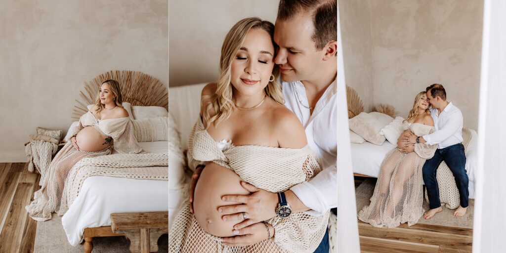 Pregnant woman draped in open-knit robe sitting on bed with neutral boho decor during cozy maternity photoshoot in Tampa studio