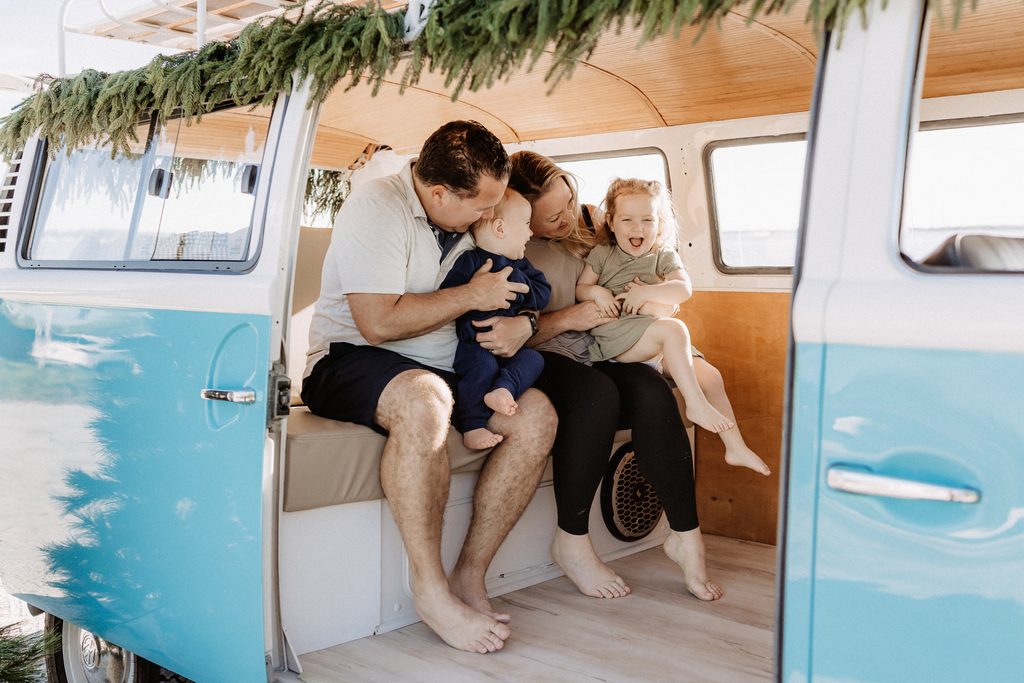 Christmas mini session setup with a decorated turquoise vintage blue bus on St. Pete Beach, Florida.