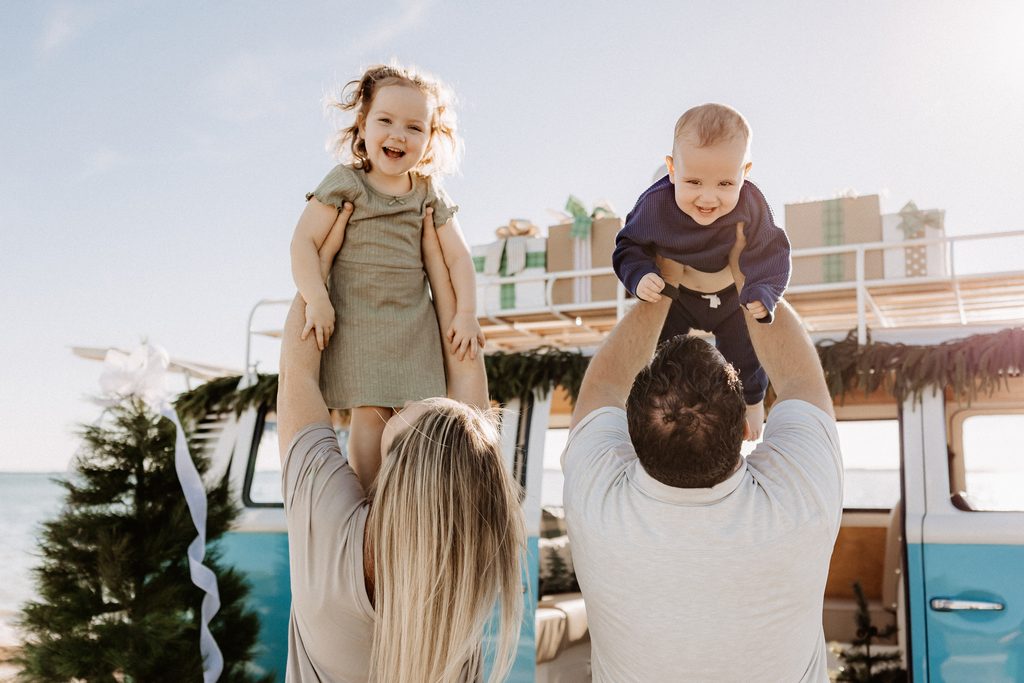Christmas mini session setup with a decorated turquoise vintage blue bus on St. Pete Beach, Florida.