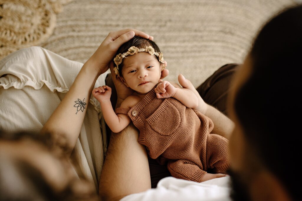 Newborn photography family session woman with baby with man on bed in studio in Tampa Bay, Florida Nadine B Photography