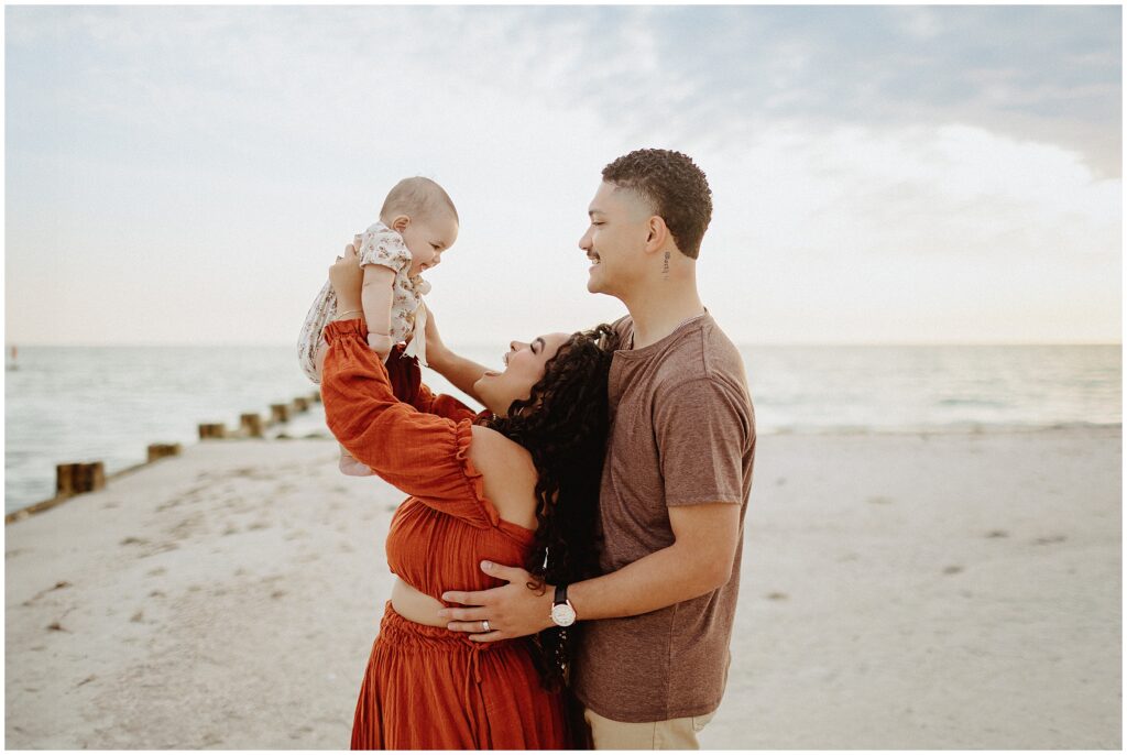 Beautiful family moment captured at Honeymoon Island beach, showcasing a couple and their child in coordinated outfits