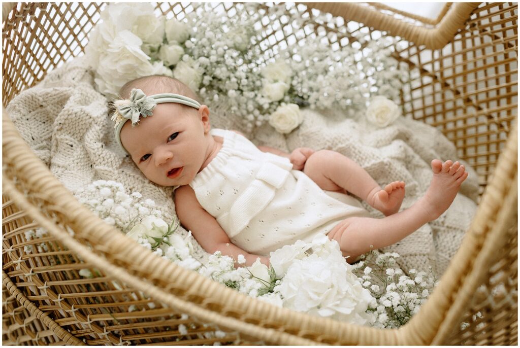 Sweet image of a newborn baby girl amidst baby's breath flowers, creating a beautiful and timeless portrait