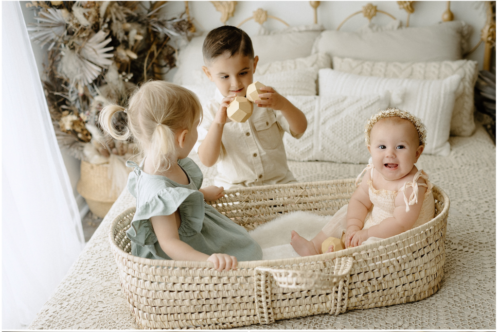 Siblings playing in woven basket  in Springhill florida studio