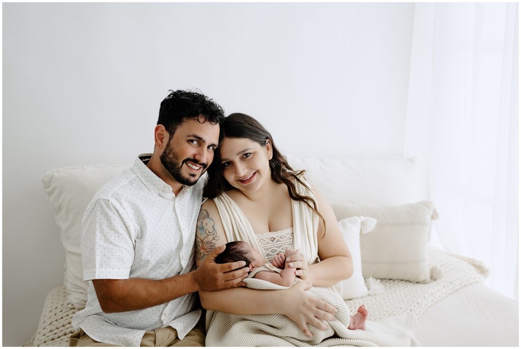 Smiling photo of newborn baby and parents in Springhill Florida studio