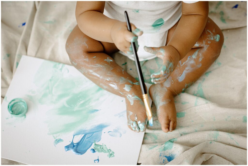 close up of little boy's feet painting on a canvas at springhill florida photography studio