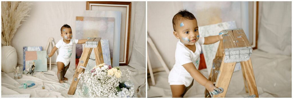 Little boy in a white onesie painting with blue paint at springhill florida photography studio