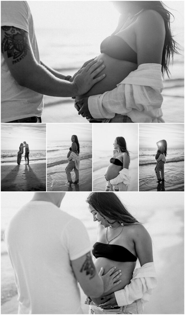 black and white maternity portraits of mom wearing jeans and white button up while in water at springhill florida beach