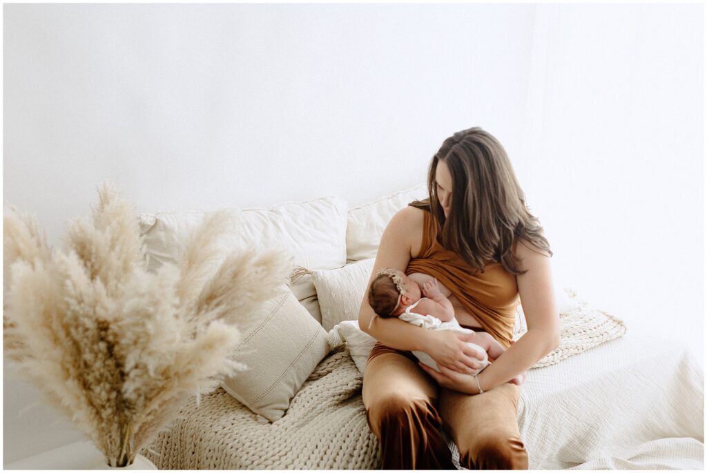 Photo of mom breastfeeding and enjoying their time during a newborn photography session at springhill florida photography studio.
