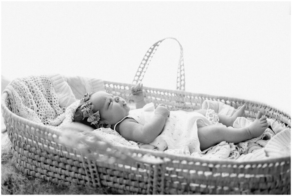 black and white photo of newborn baby girl in floral crown in basket at springhill florida photography studio