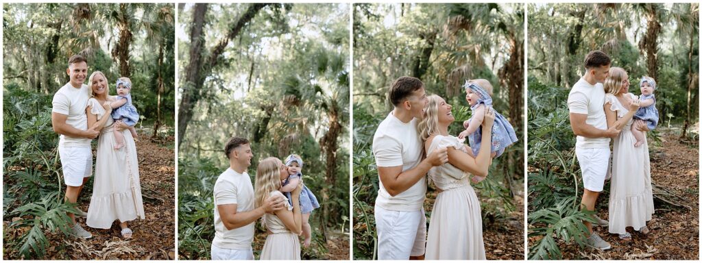 Baby in a blue and gold floral dress being lifted by mom while dad plays with baby in front of palm trees