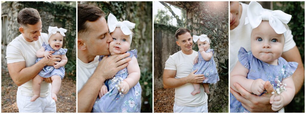 Close-up of dad kissing baby’s forehead, baby in a blue and white floral dress with a white bow.
