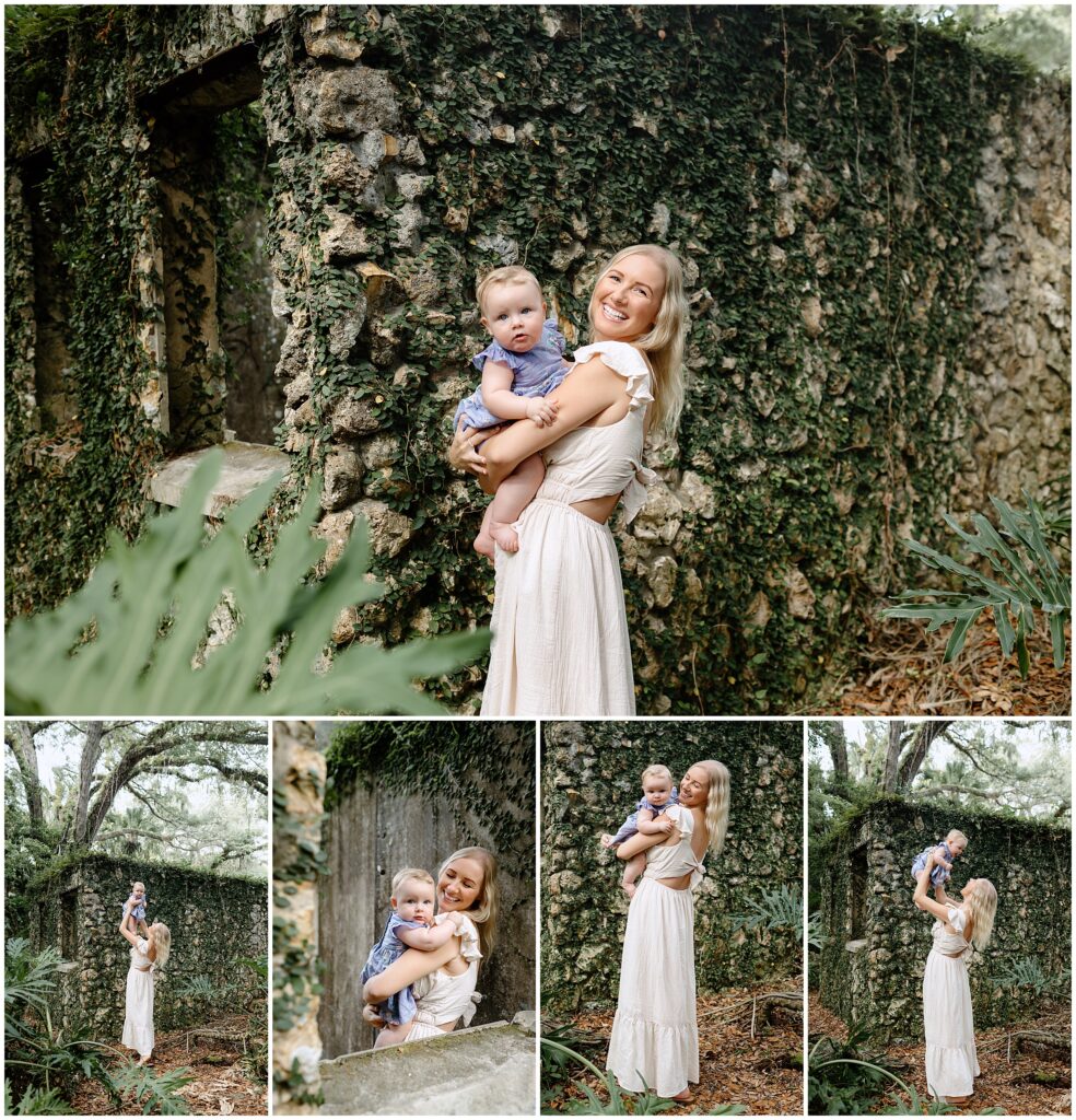 Mom in a white dress cradling baby in a blue and white floral dress with a white bow, against the ruins backdrop.