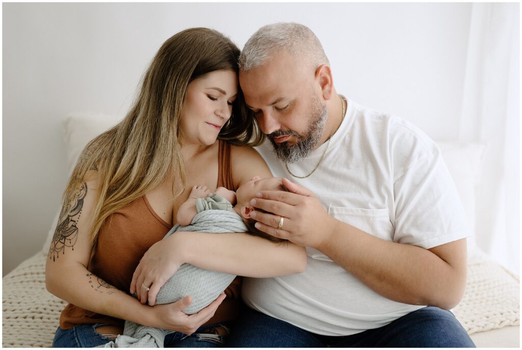 Newborn baby adored by mom and dad in a family portrait session in Spring Hill, FL