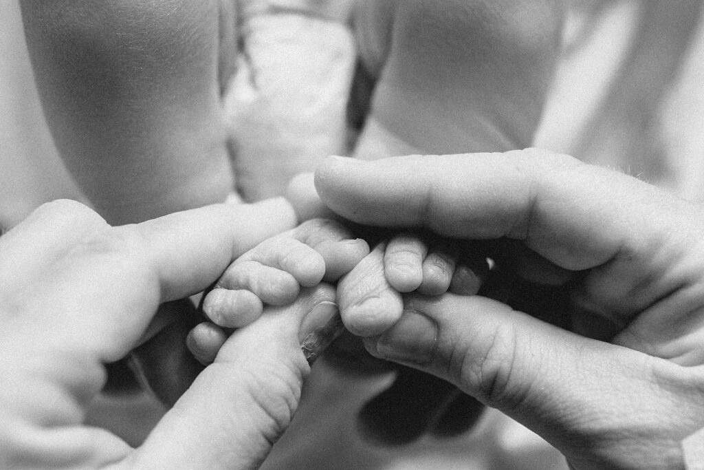 Black and white detail photo of newborn baby feet in mom's hands, Fresh 48 session at Oak Hill Hospital in Brooksville