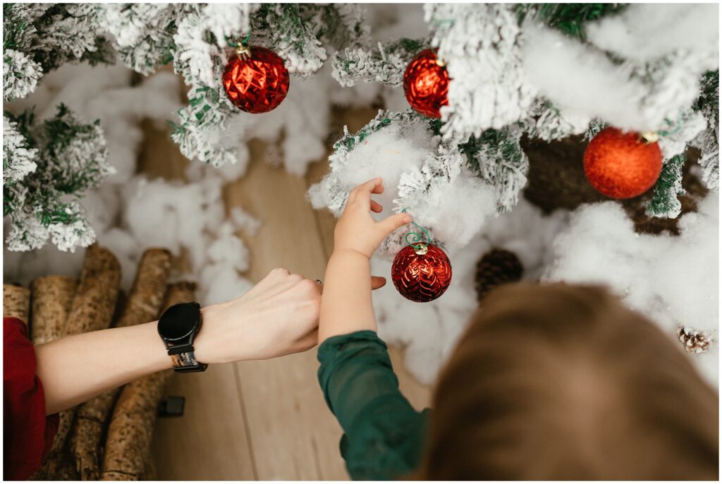 Close up image of little girl and mom hanging ornaments at Winter Wonderland Cottage in Tampa