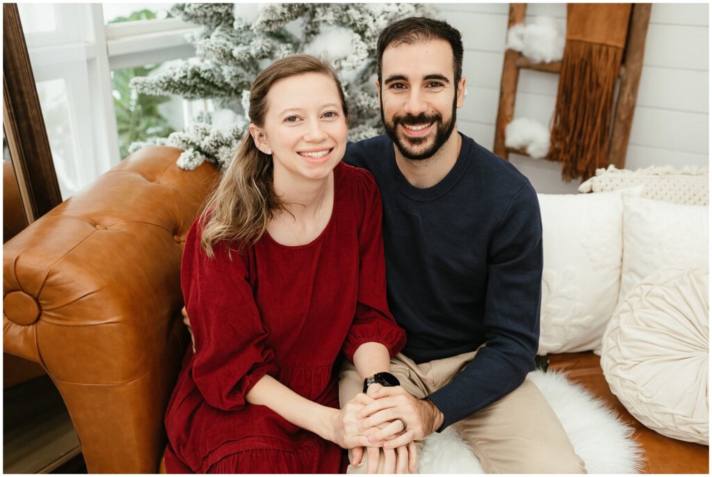 Mom in red dress with dad in blue sweater during Tampa holiday session