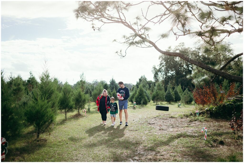 Mom, dad, and children walking by the Christmas trees at Blue Acres Christmas Tree Farm in Tampa