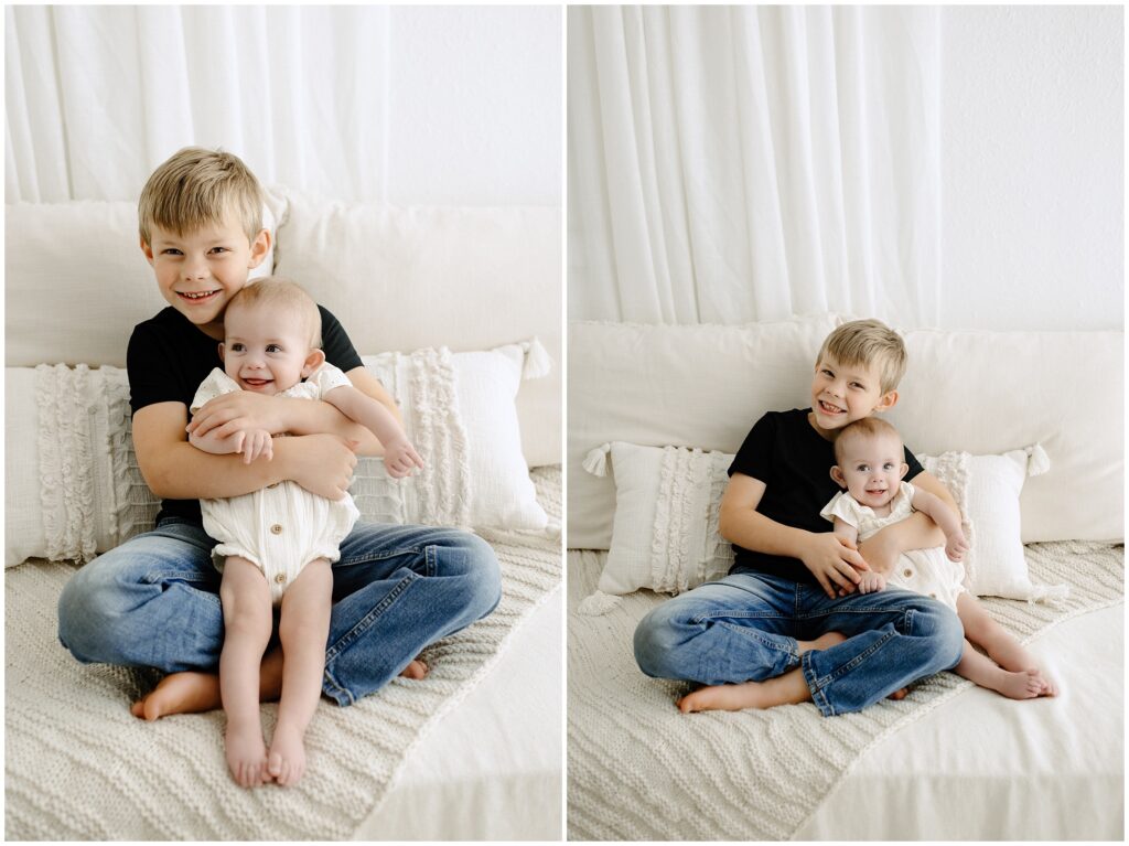 Little sister sitting with big brother, snuggling and laughing on bed in Spring Hill Studio in Florida