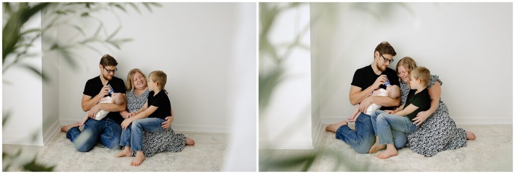 Lifestyle family portraits of family sitting on floor snuggling while little girl drinks bottle with dad Spring Hill Studio in Florida