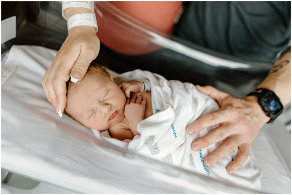 Mom and dad's hands on sleeping newborn baby, fresh 48 hospital newborn session in Florida