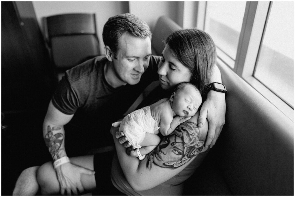 Black and white photo of new parents cuddling with newborn baby fresh 48 hospital newborn session in Florida