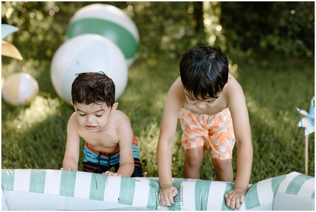 Boys jumping into the inflatable pool together