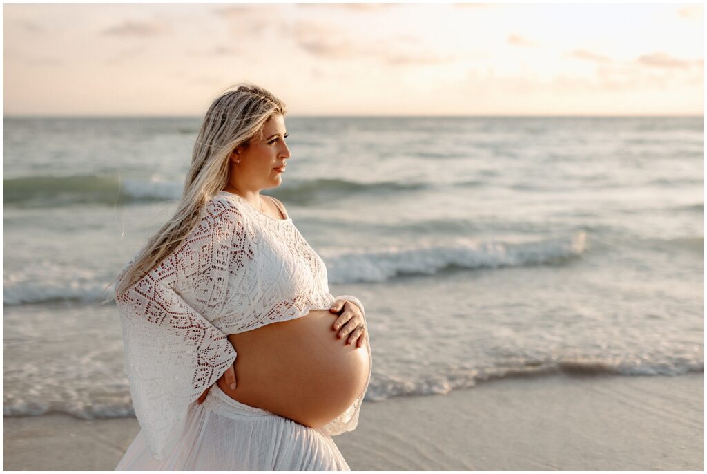 Close up portrait of blonde pregnant woman in water during golden hour maternity session in Tampa