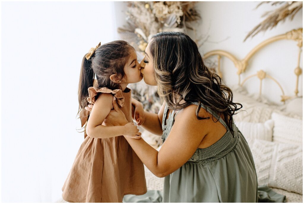 Mom standing and kissing daughter at Vibe Studio Spring Hill in Florida