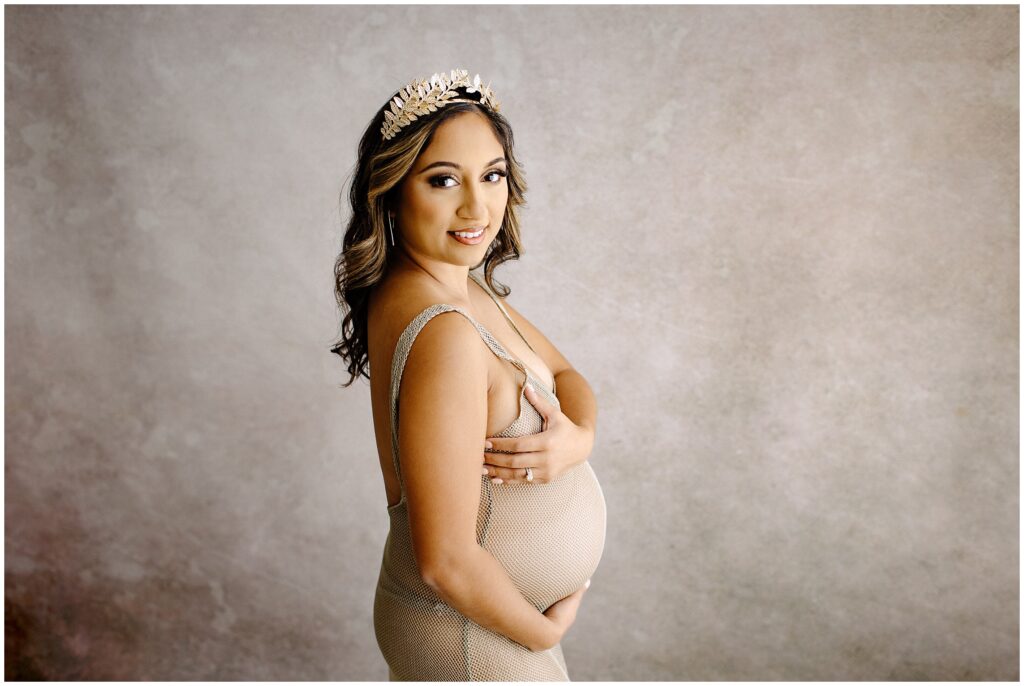 Pregnant woman wearing floral tiara in nude knit dress at Vibe Studio Spring Hill in Florida