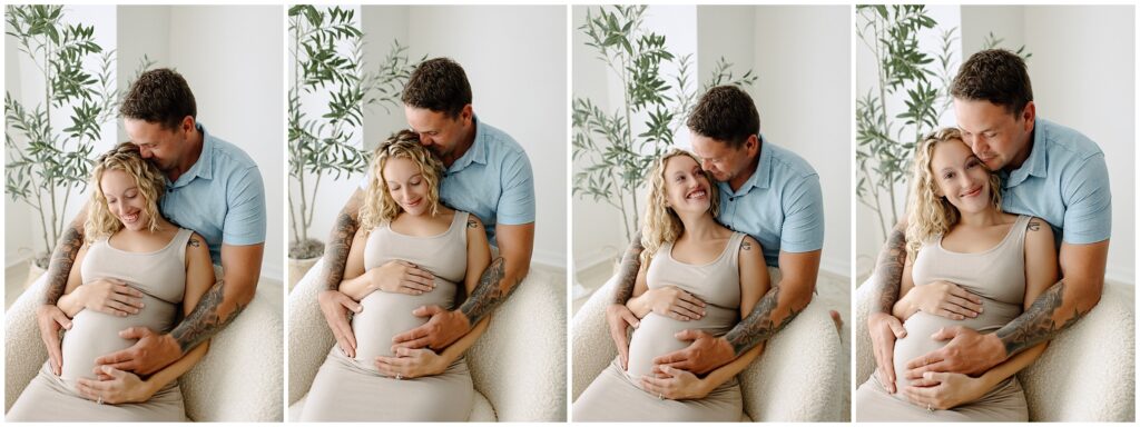 Pregnant woman sitting on white beanbag with husband holding her stomach at Spring Hill Studio in Florida. 