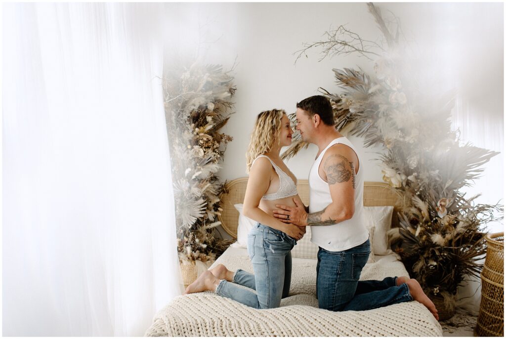 Couple playing and laughing barefoot in jeans and white tops at Spring Hill Studio in Florida.
