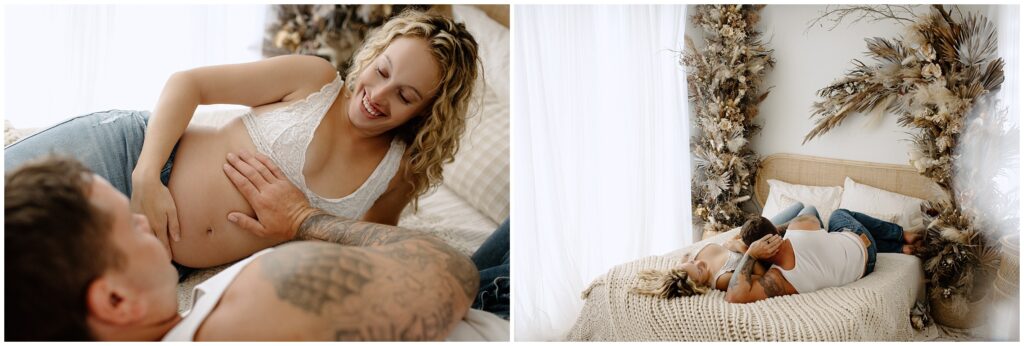 Pregnant couple in jeans and white tops laying on bed in Spring Hill studio 