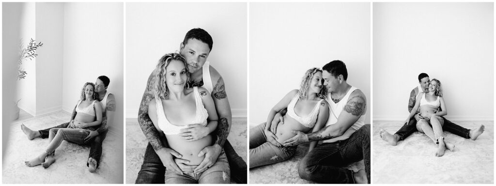 Black and white maternity portrait of couple in jeans and white tops, snuggling barefoot on the floor at Spring Hill Studio in Florida.
