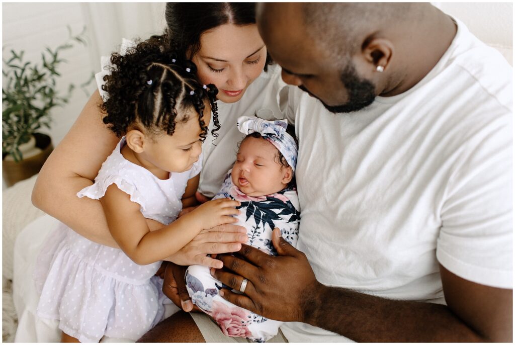 Close up portrait of family of 4 holding baby girl newborn session at Spring Hill Studio in Florida