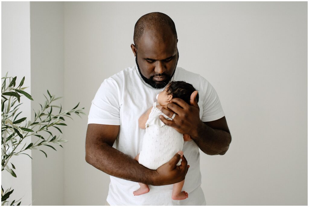 Dad holding newborn baby daughter newborn session at Spring Hill Studio in Florida