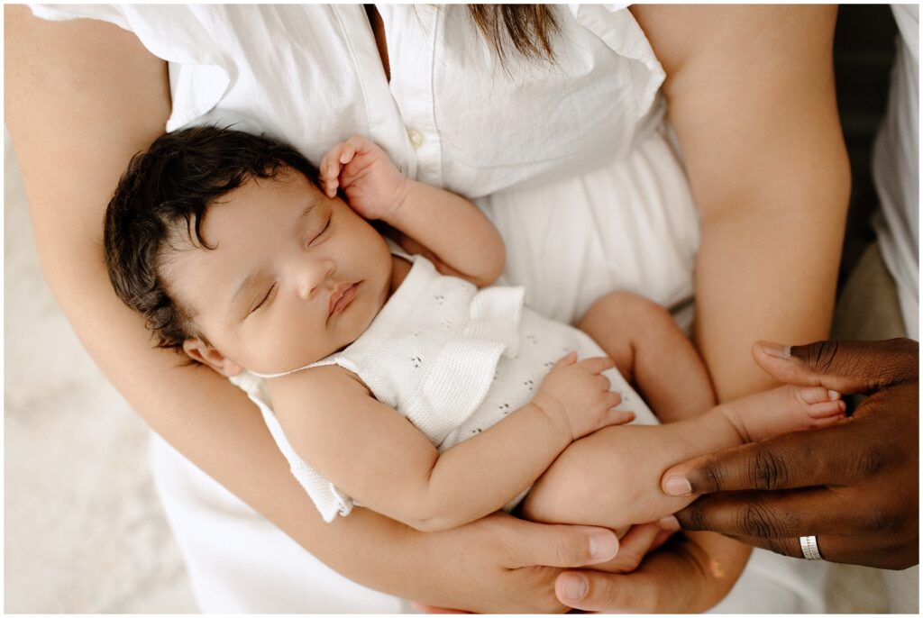 Newborn baby girl snuggling in mom and dad's arms, close up photo, newborn session at Spring Hill Studio in Florida